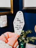 A white marble acrylic motel chain engraved with black sparkles and the text "i'm doing good i'm on some new shit."