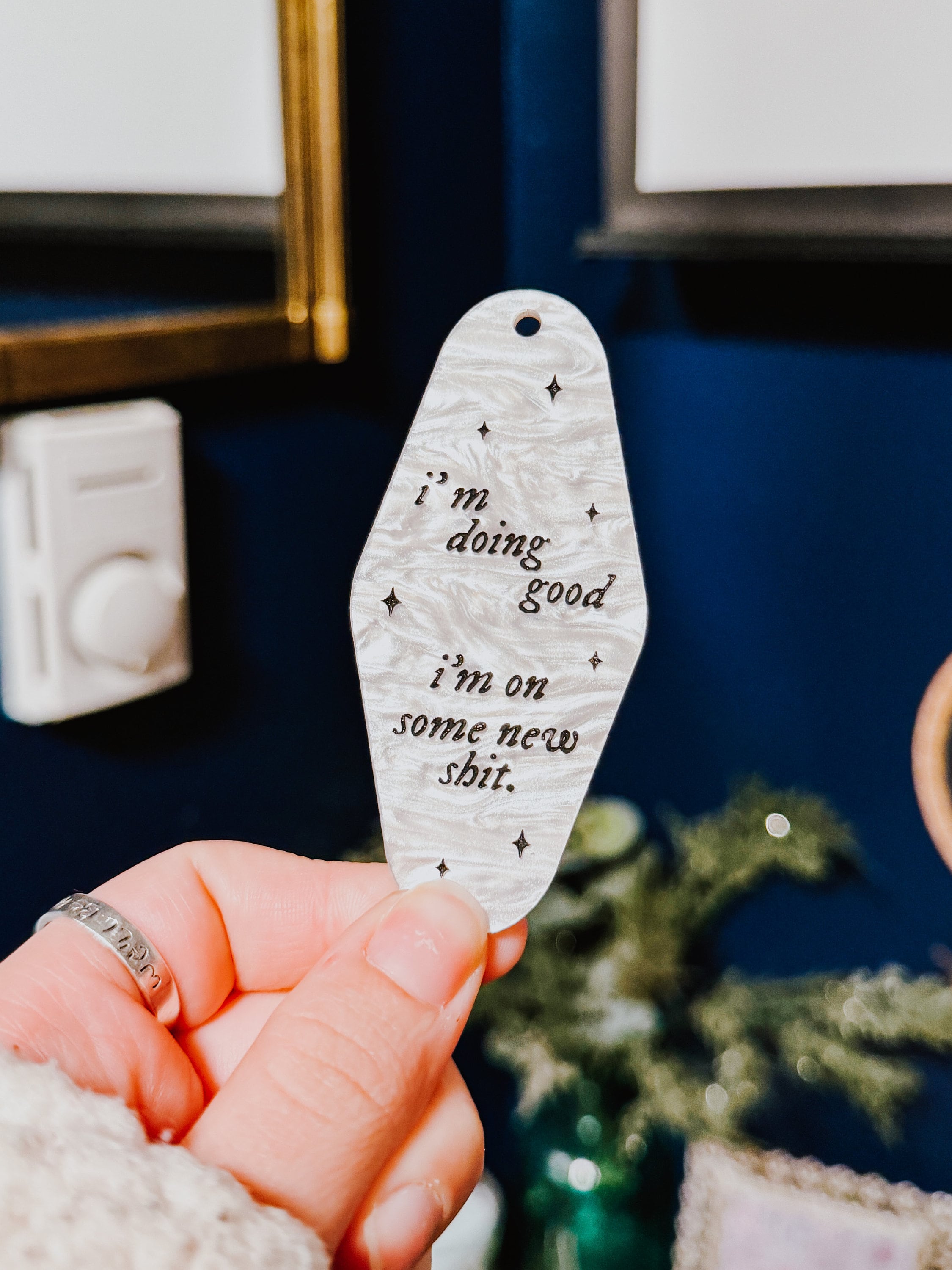A white marble acrylic motel chain engraved with black sparkles and the text "i'm doing good i'm on some new shit."