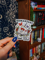 A transparent sticker with a book, butterfly, sword, and rose design, with the text 'Romantasy Book Club'.