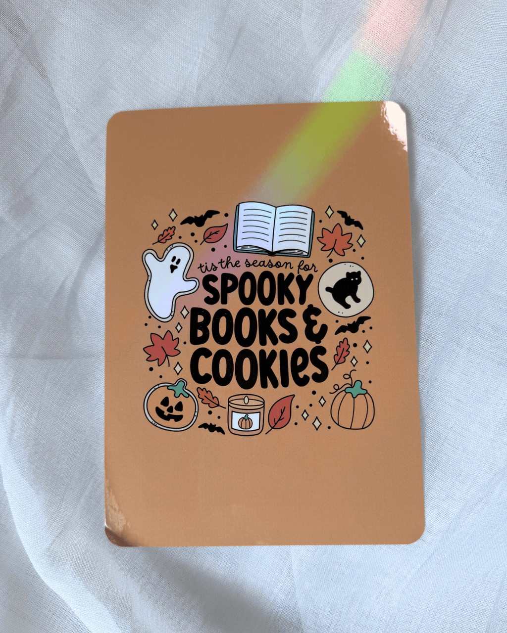 Kindle insert featuring a cute Halloween-themed graphic that reads 'tis the season for spooky books & cookies' surrounded by illustrations of a ghost, leaves, cookies, etc.