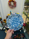 A circular blue wind spinner with white stars and text with the lyrics 'to live for the hope of it all' by taylor swift